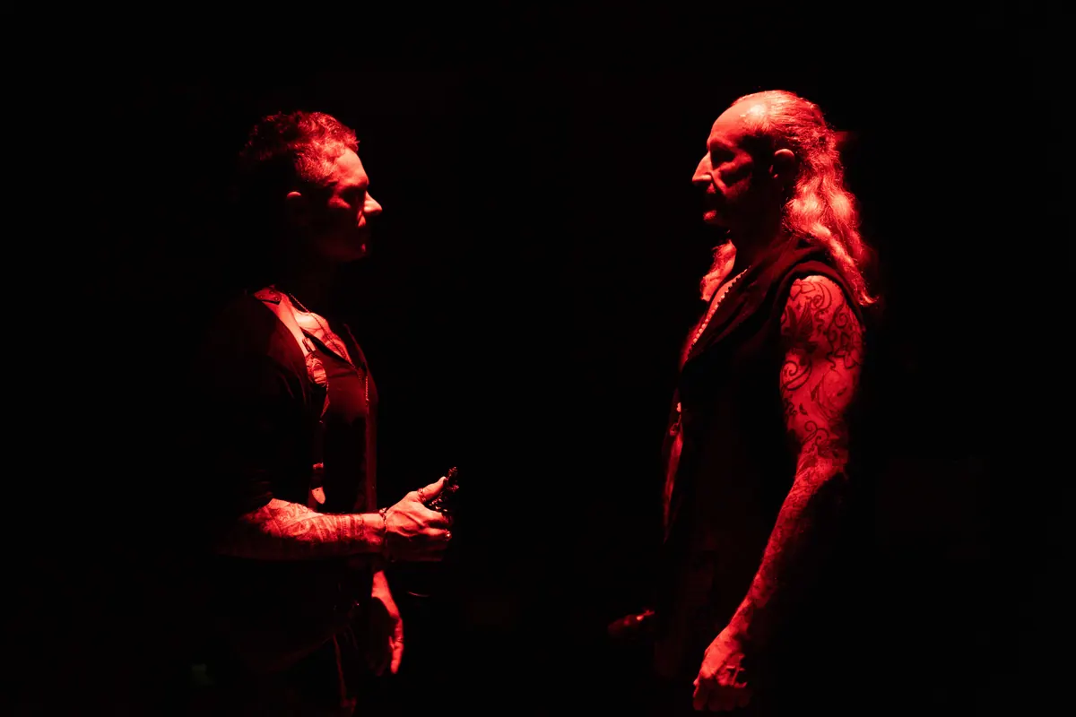 Two men facing each other in red light