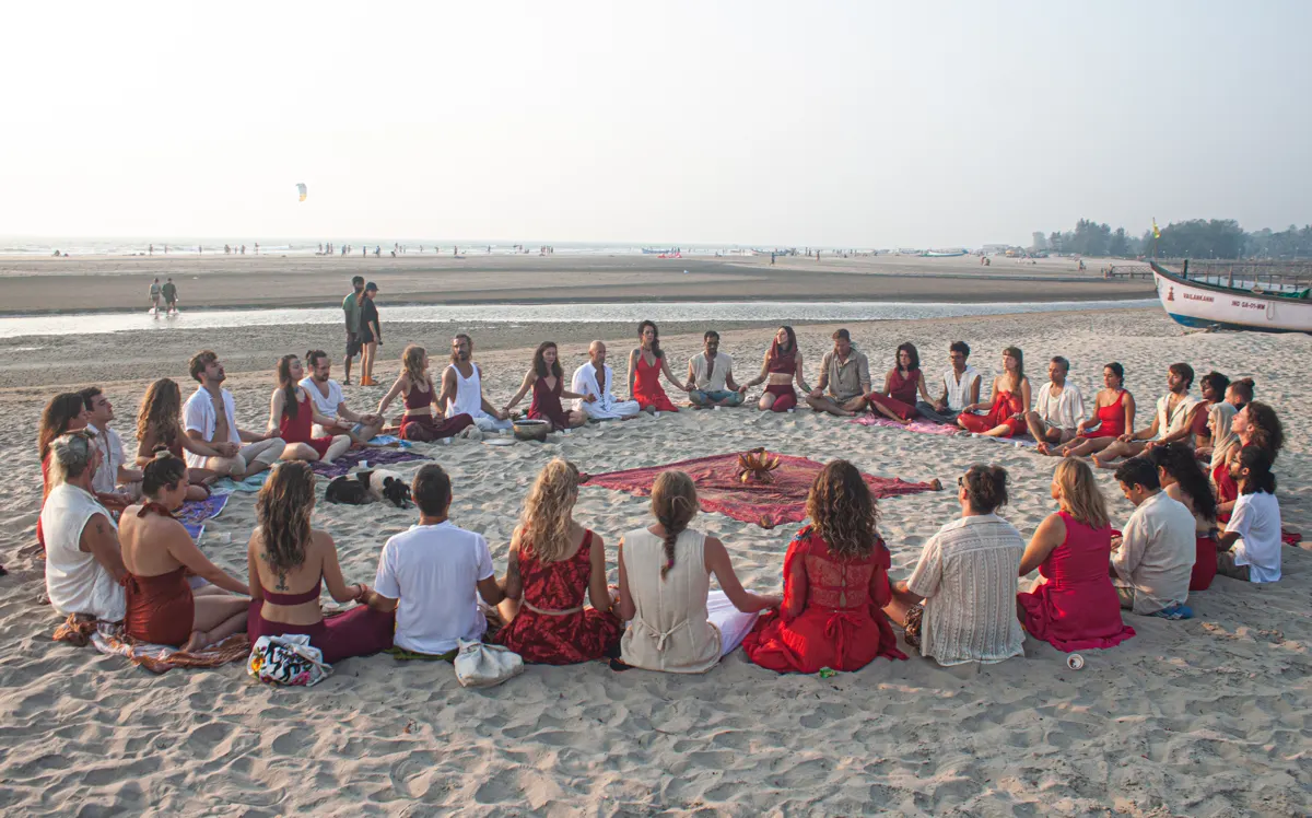 Men and women in a great circle on the beach