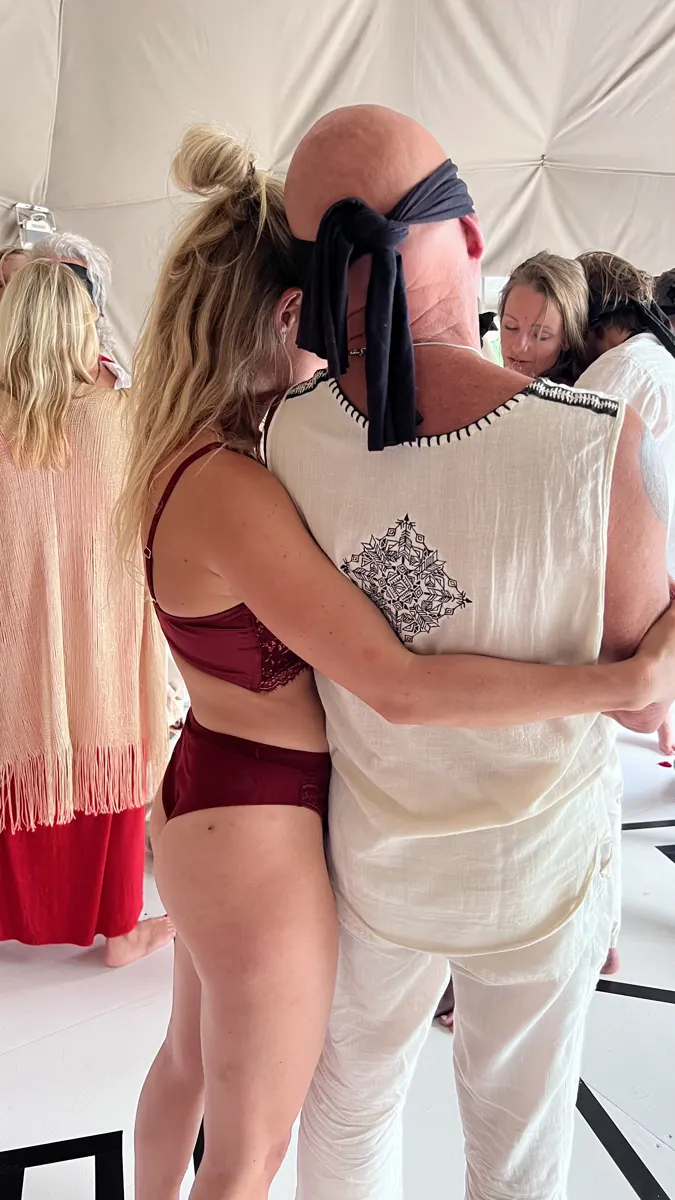 A blindfolded man held by a woman