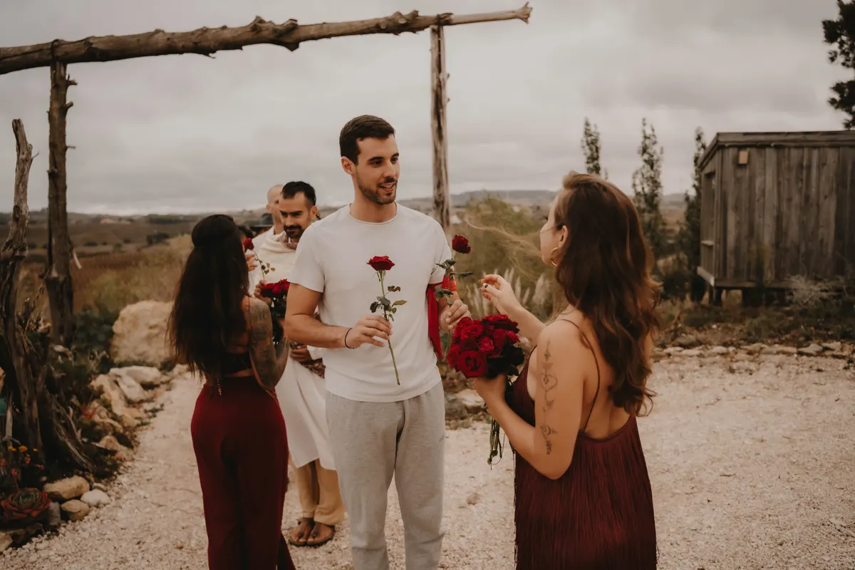 Men in white meeting the women in red with a rose