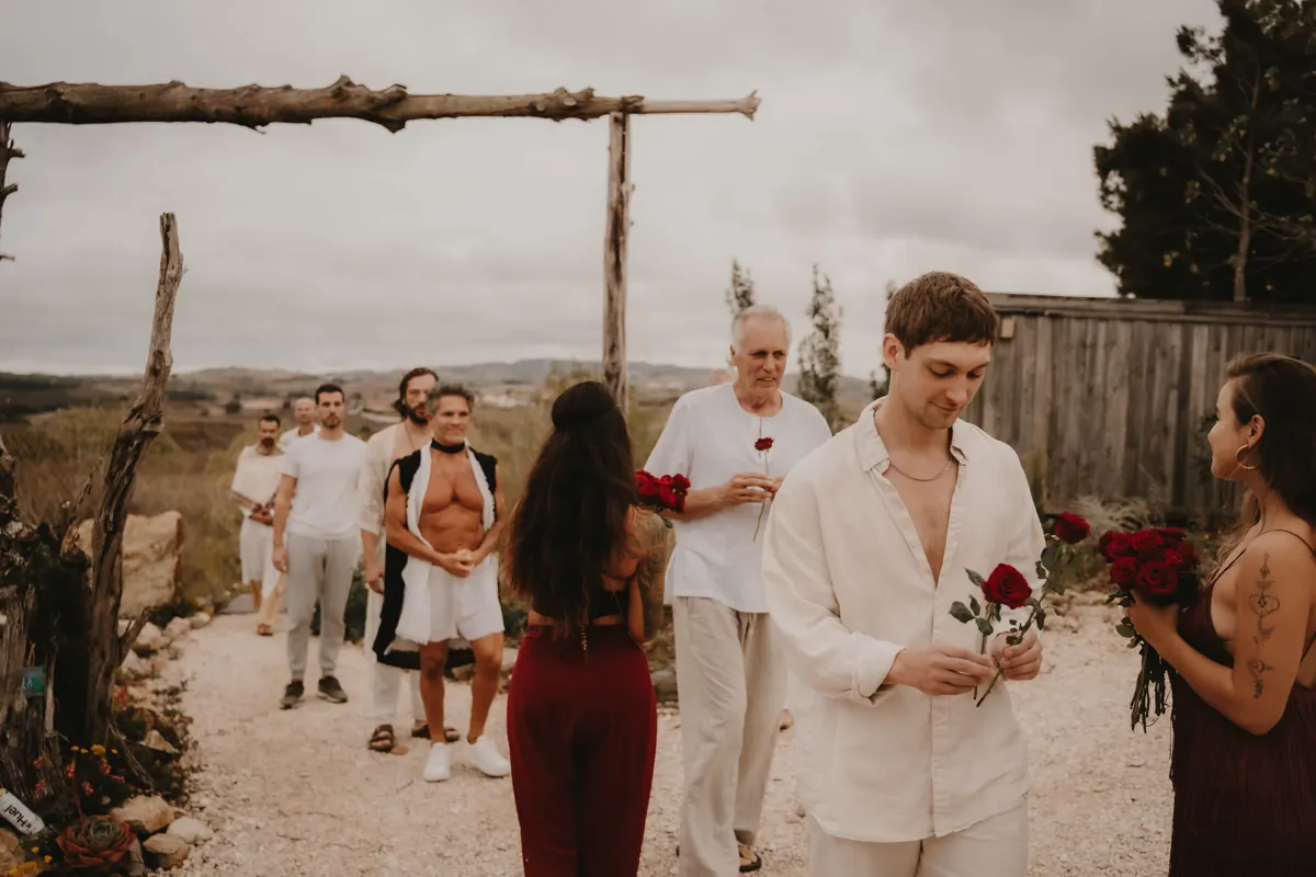 A man in white offering a rose